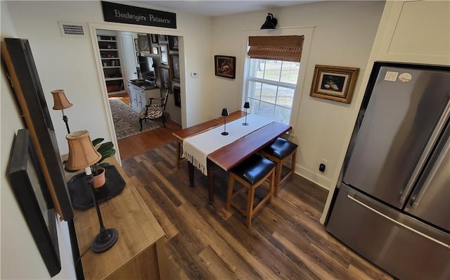 dining area featuring visible vents, baseboards, and dark wood-style flooring