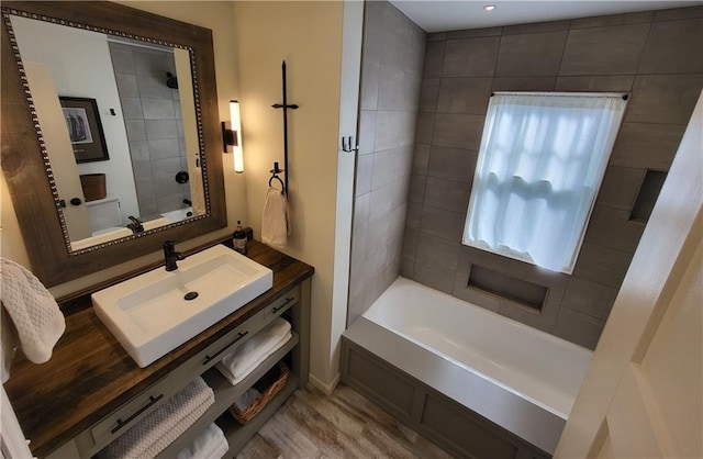 full bathroom with wood finished floors and a sink