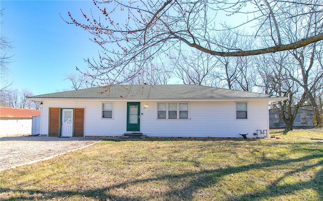 ranch-style home featuring entry steps, a front lawn, and gravel driveway