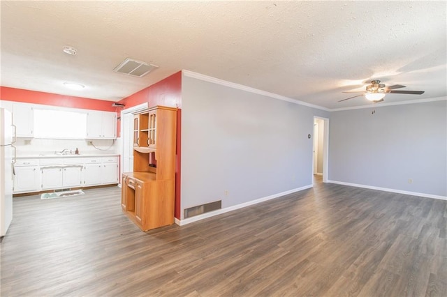 unfurnished living room featuring visible vents, dark wood finished floors, and a textured ceiling