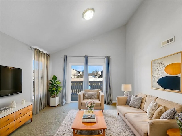 living area featuring high vaulted ceiling, visible vents, and light colored carpet