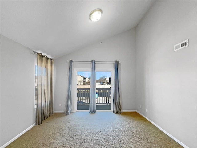 carpeted empty room with baseboards, visible vents, and vaulted ceiling