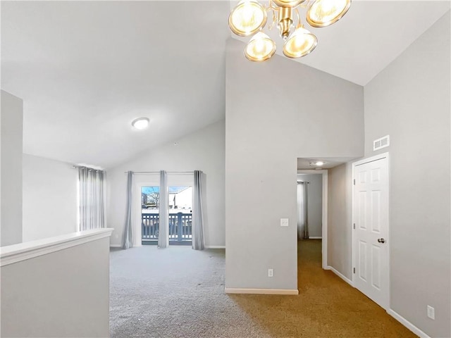 corridor featuring carpet floors, a notable chandelier, visible vents, high vaulted ceiling, and baseboards