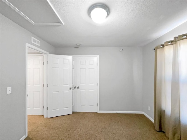 unfurnished bedroom featuring carpet floors, baseboards, visible vents, and a textured ceiling