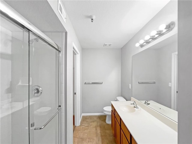 bathroom featuring toilet, visible vents, vanity, baseboards, and a shower stall