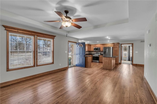 kitchen with light wood-style flooring, visible vents, baseboards, appliances with stainless steel finishes, and dark countertops