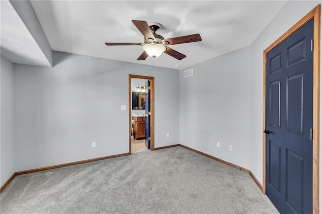 empty room with light carpet, ceiling fan, visible vents, and baseboards