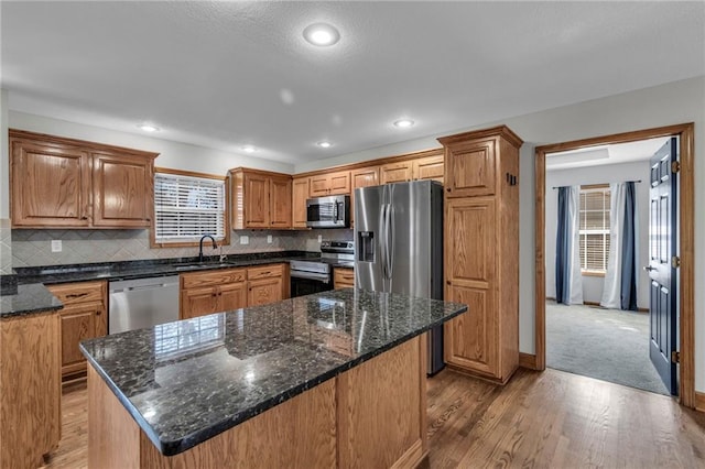 kitchen featuring appliances with stainless steel finishes, plenty of natural light, a sink, and tasteful backsplash