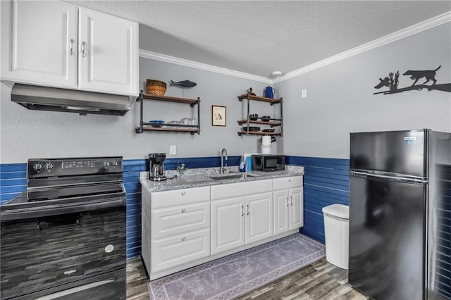 kitchen featuring crown molding, wainscoting, a sink, under cabinet range hood, and black appliances