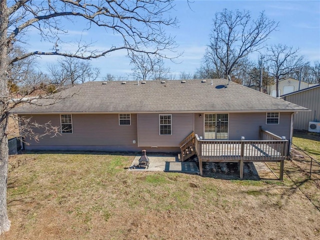 rear view of property with roof with shingles, a yard, and a wooden deck