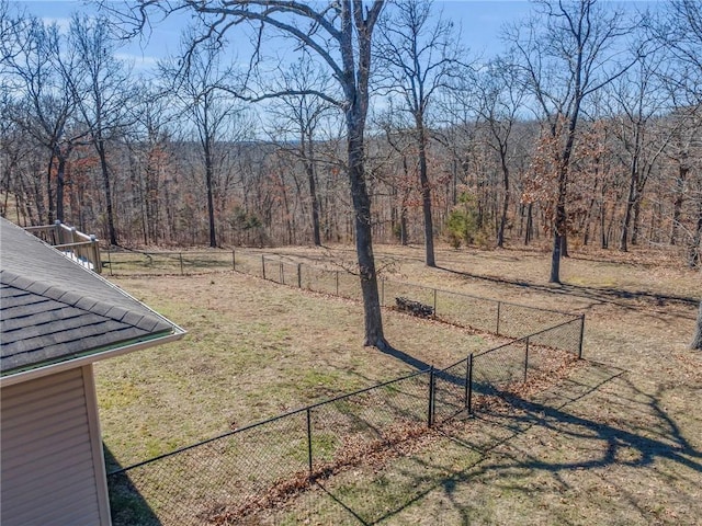 view of yard with fence and a forest view