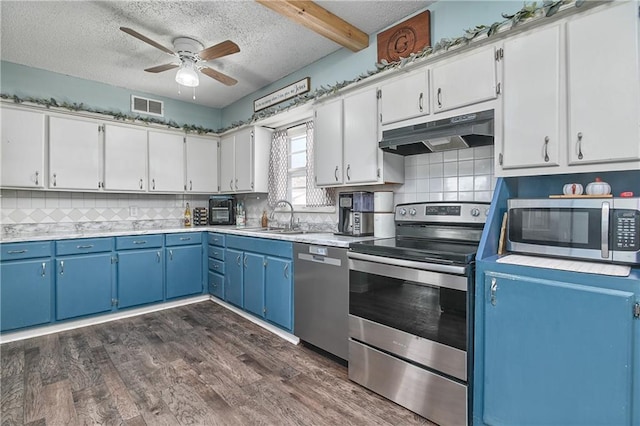 kitchen featuring under cabinet range hood, visible vents, blue cabinetry, and appliances with stainless steel finishes