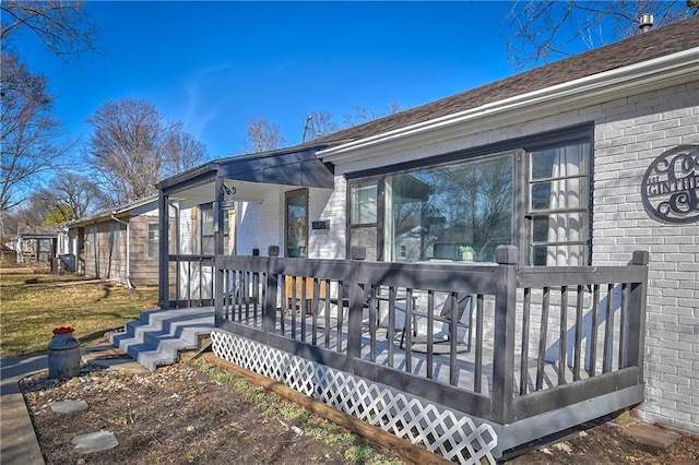 exterior space with brick siding and a deck