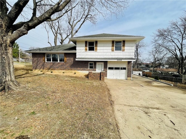 tri-level home featuring driveway, brick siding, and an attached garage