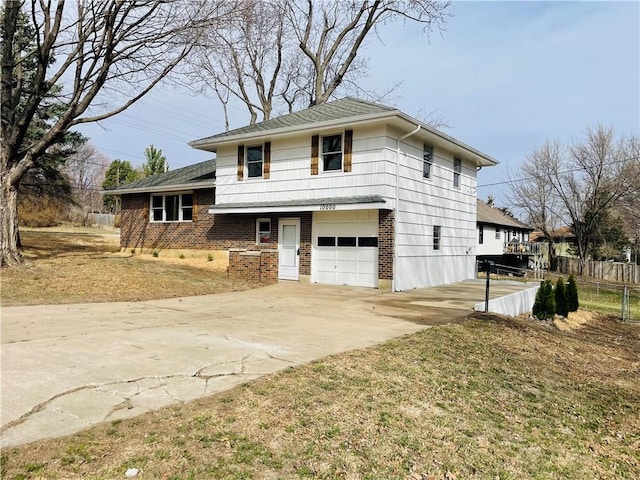 split level home featuring brick siding, an attached garage, concrete driveway, and fence