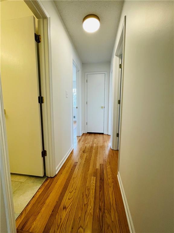 hall featuring baseboards and light wood finished floors