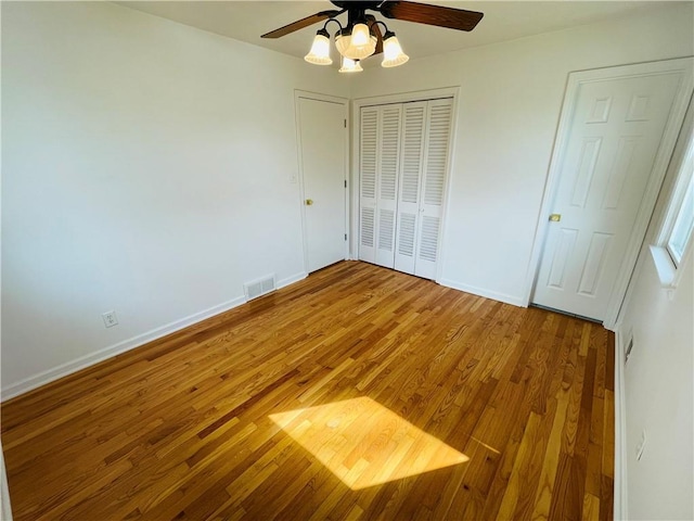 unfurnished bedroom with visible vents, light wood-style flooring, a closet, baseboards, and ceiling fan