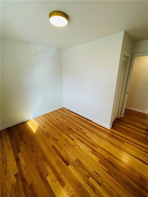 unfurnished room with baseboards and wood finished floors