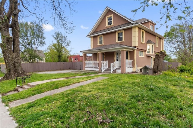 3711 E 9th St, Kansas City, MO 64124 - view of front of home with covered porch, a front yard, fence, and stucco siding