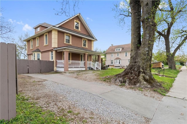 view of front of house featuring covered porch, fence, concrete driveway, and stucco siding