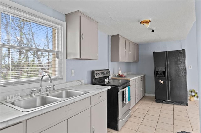 kitchen featuring light tile patterned floors, a sink, electric stove, light countertops, and black refrigerator with ice dispenser