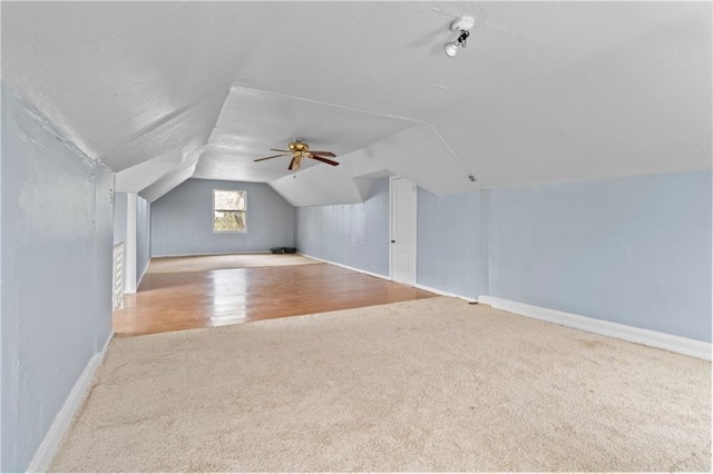 additional living space featuring carpet flooring, vaulted ceiling, and baseboards