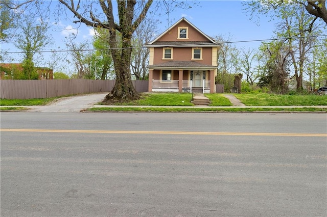 view of front of house with covered porch, fence, and stucco siding