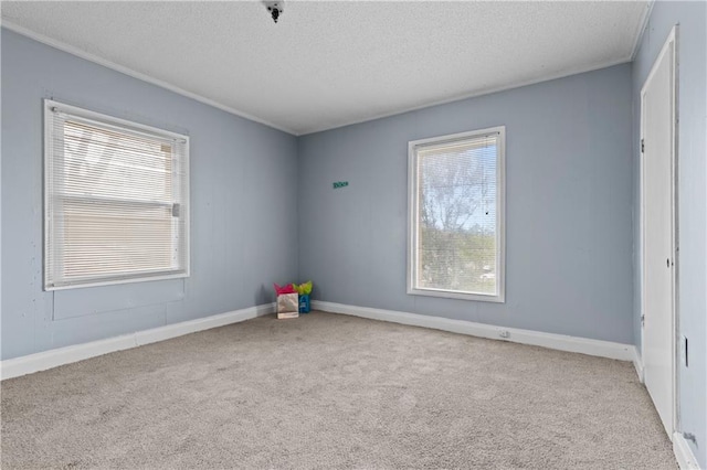 carpeted spare room with a textured ceiling and baseboards