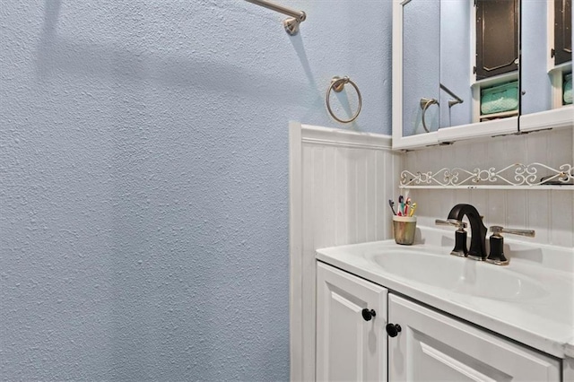 bathroom featuring vanity and a textured wall