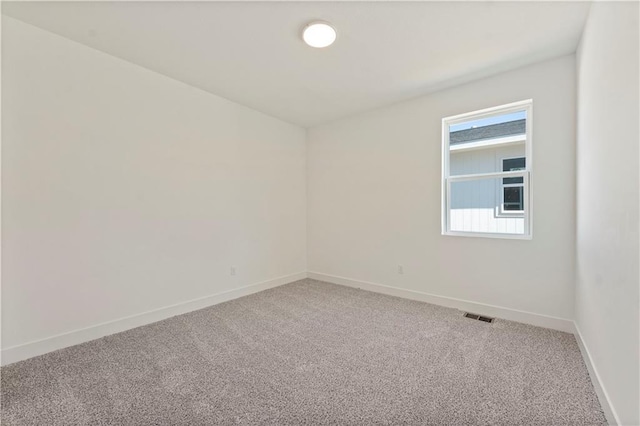 unfurnished room with visible vents, light carpet, and baseboards