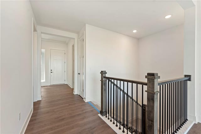 hall featuring recessed lighting, baseboards, wood finished floors, and an upstairs landing