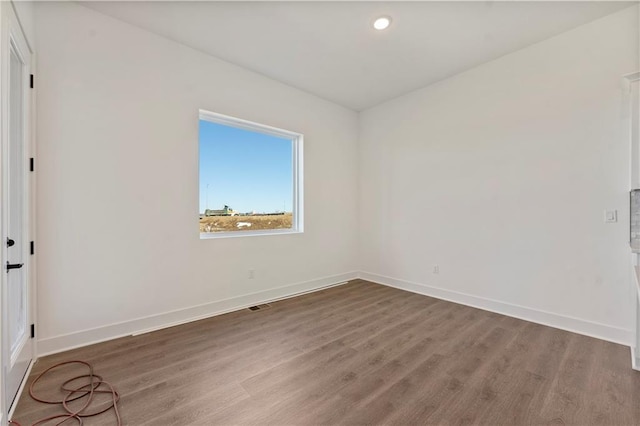 spare room featuring recessed lighting, visible vents, baseboards, and wood finished floors