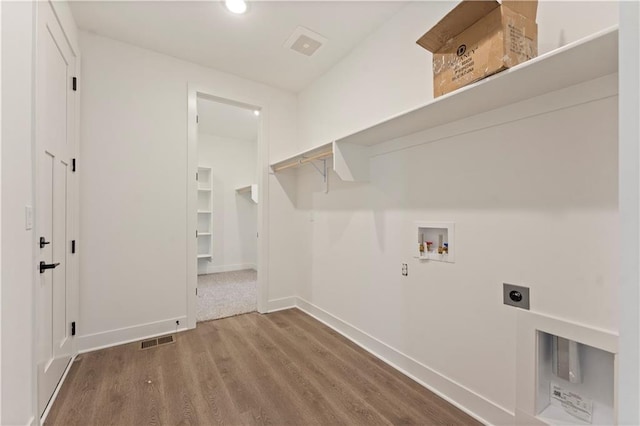 clothes washing area with hookup for a washing machine, laundry area, wood finished floors, visible vents, and electric dryer hookup