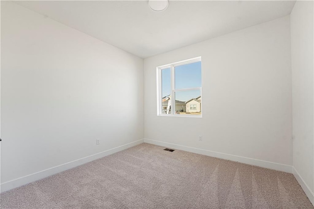 spare room with light carpet, visible vents, and baseboards