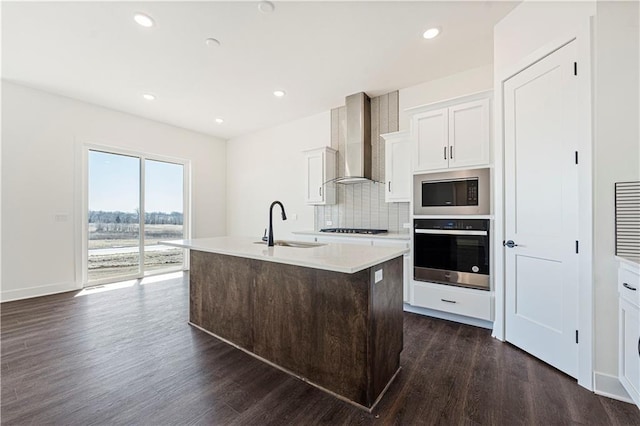 kitchen featuring wall oven, a sink, wall chimney range hood, built in microwave, and dark wood-style floors