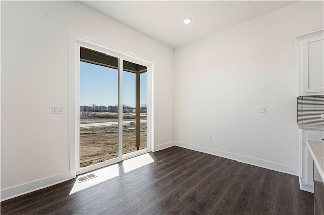 spare room with dark wood-type flooring, recessed lighting, visible vents, and baseboards