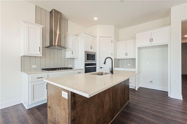 kitchen featuring stainless steel microwave, a sink, wall chimney range hood, gas cooktop, and oven