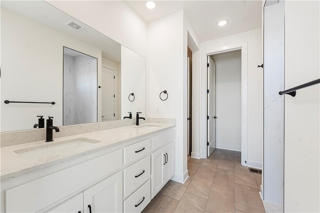 bathroom with double vanity, visible vents, a sink, and recessed lighting