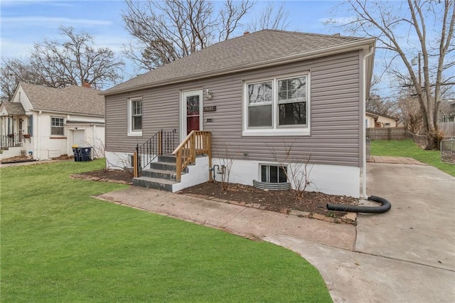 bungalow-style house with roof with shingles, fence, and a front lawn