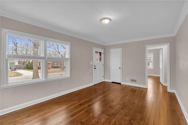 interior space featuring crown molding, hardwood / wood-style floors, and baseboards