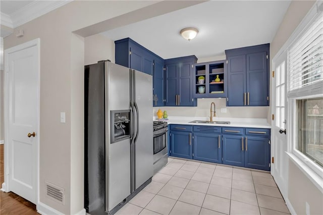 kitchen featuring appliances with stainless steel finishes, light countertops, crown molding, blue cabinetry, and a sink