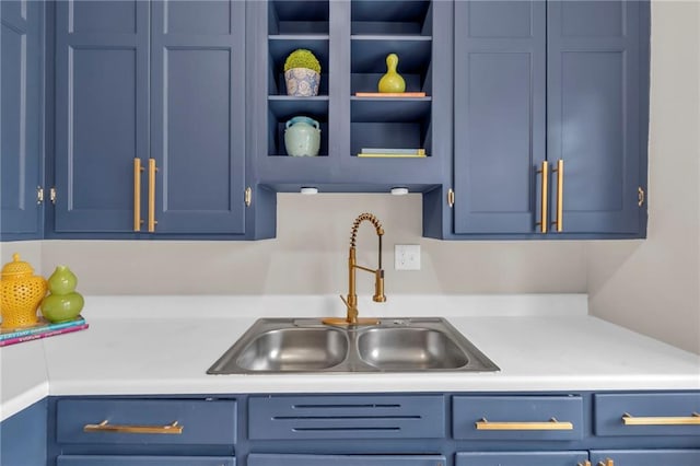 kitchen with blue cabinetry, light countertops, and a sink