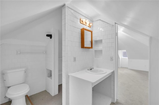 full bath with tile walls, bathing tub / shower combination, toilet, vaulted ceiling, and vanity