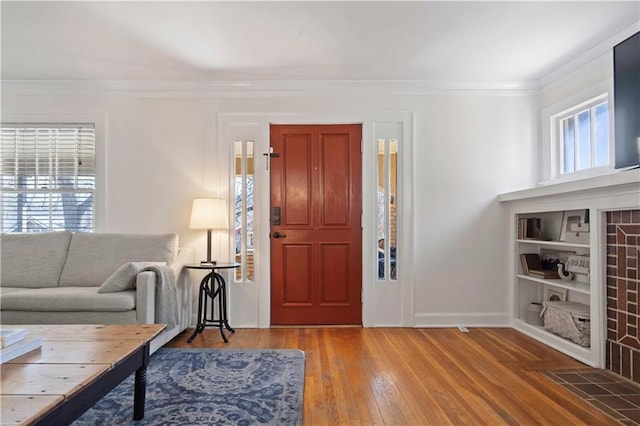 living area with hardwood / wood-style flooring, baseboards, and ornamental molding