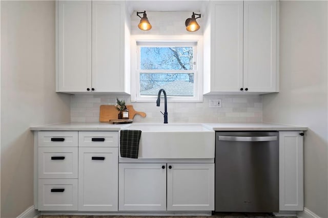 kitchen featuring a sink, decorative backsplash, stainless steel dishwasher, and white cabinets