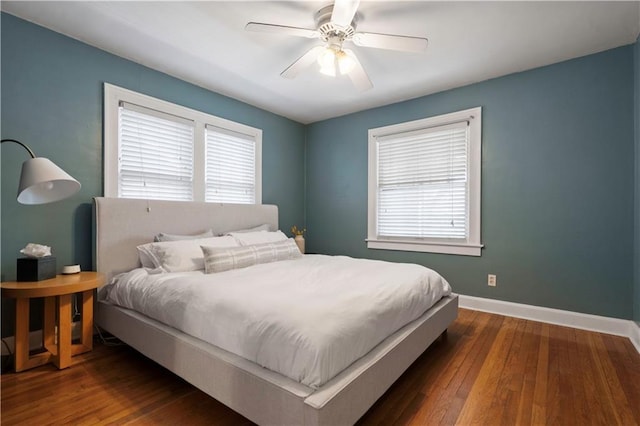 bedroom with multiple windows, a ceiling fan, baseboards, and wood-type flooring