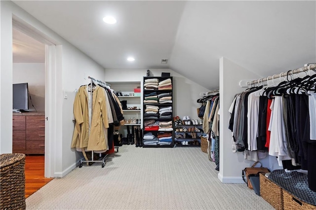 walk in closet with lofted ceiling and carpet floors