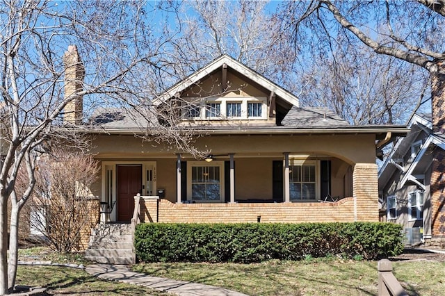 bungalow-style home featuring a porch and brick siding