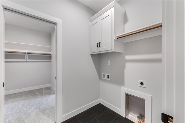 laundry area with hookup for an electric dryer, dark tile patterned flooring, baseboards, cabinet space, and dark carpet