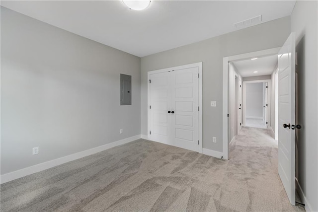 unfurnished bedroom with visible vents, baseboards, a closet, electric panel, and carpet